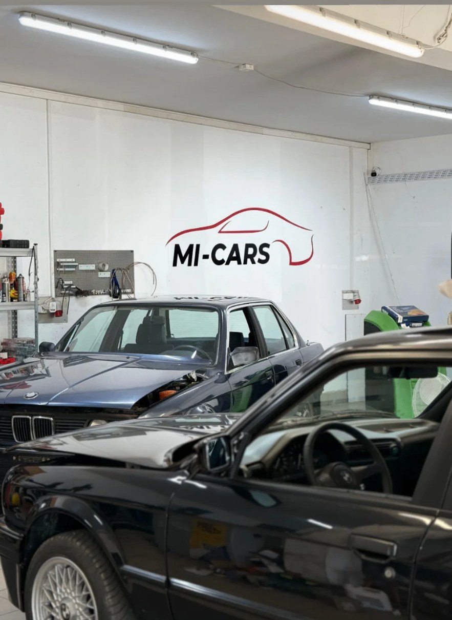 Hala warsztatu MI-CARS Auto Serwis z logo i BMW E30